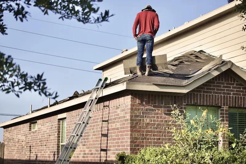Professional roofer working on a residential roof in Longmeadow